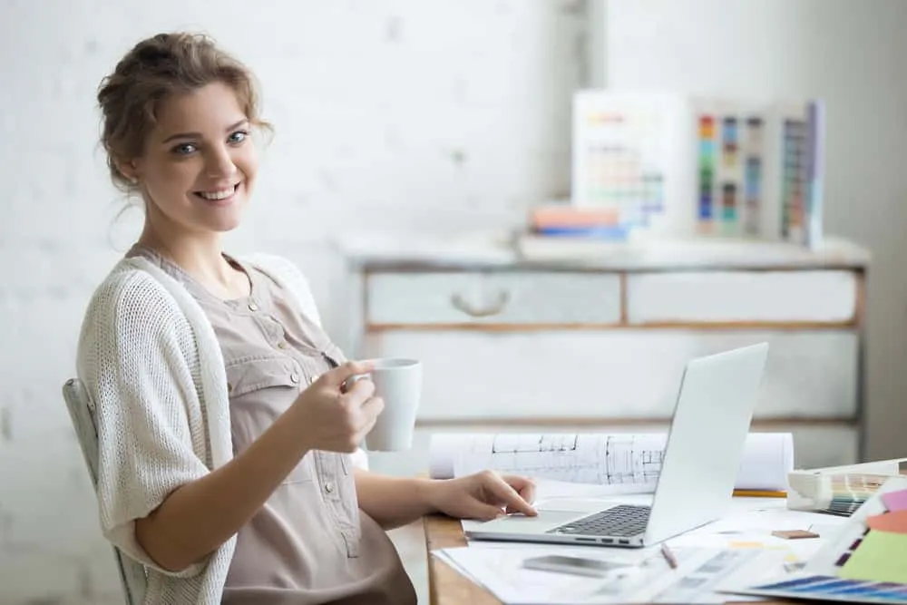 Portrait,Of,Beautiful,Happy,Smiling,Young,Designer,Woman,Sitting,At woman working remotely